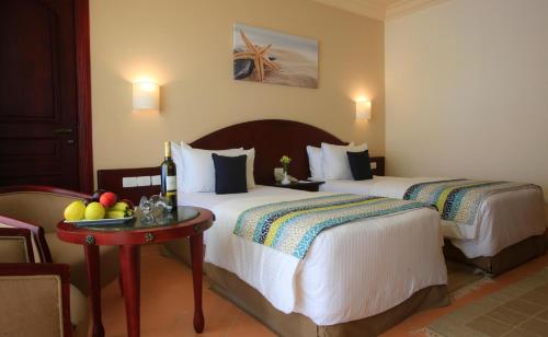 a hotel room with two beds and a table with fruit at Labranda Royal Makadi in Hurghada