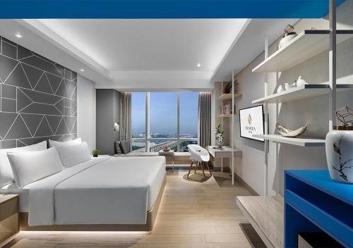 a bedroom with a white bed and a desk at Nuanza Hotel & Convention Cikarang in Cikarang