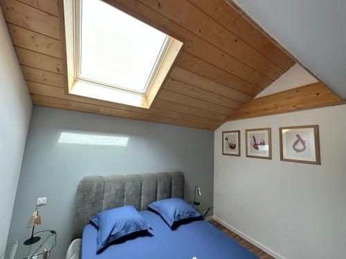a bedroom with a bed and a skylight at LES ANTHOCYANES in Champagny