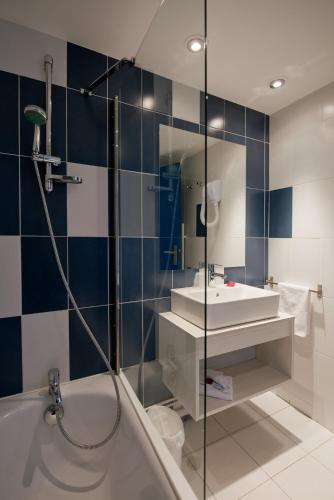 une salle de bain avec une baignoire, un lavabo et une douche dans l'établissement SOWELL RESIDENCES Les Hameaux de Camargue, à Arles