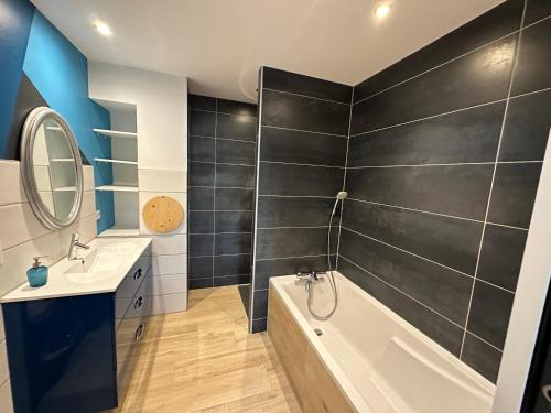 a bathroom with a white tub and a sink and a bath tub at LES ANTHOCYANES in Champagny