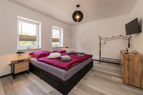 1 dormitorio con 1 cama grande con manta roja en Ferienwohnung Hopf, en Bad Liebenstein