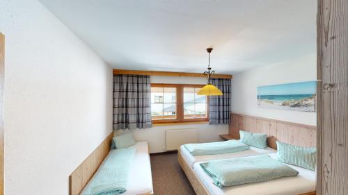 a room with two beds and a window at Apartment Daxauer in Sankt Johann in Tirol