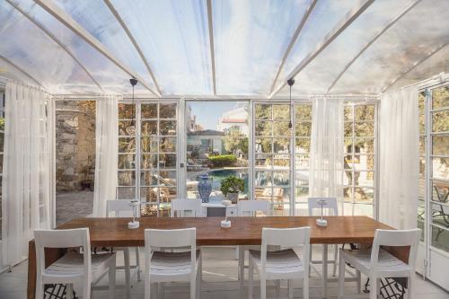 comedor con mesa de madera y sillas blancas en Panjur Alaçatı en Alacati