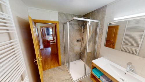 ein Bad mit einer Dusche und einem Waschbecken in der Unterkunft Apartment Daxauer in Sankt Johann in Tirol