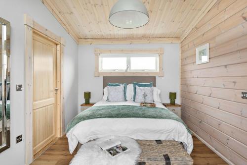 a bedroom with a bed and a window at Croftner, Great Field Lodges in Braunton