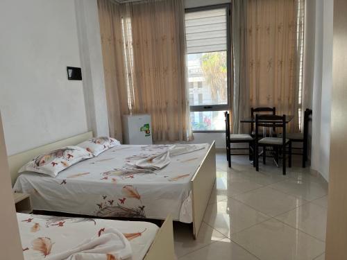 a bedroom with two beds and a table and chairs at Villa Kasa in Durrës