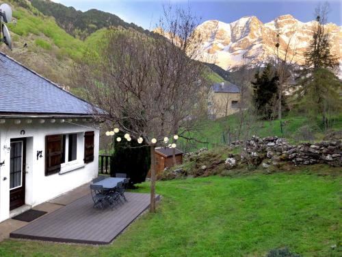 una casa con una mesa de picnic en una terraza con montañas en Gavarent, en Gavarnie