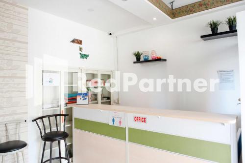 a kitchen with a counter and two stools at Happy Inn Puspo Mitra RedDoorz in Jomblang