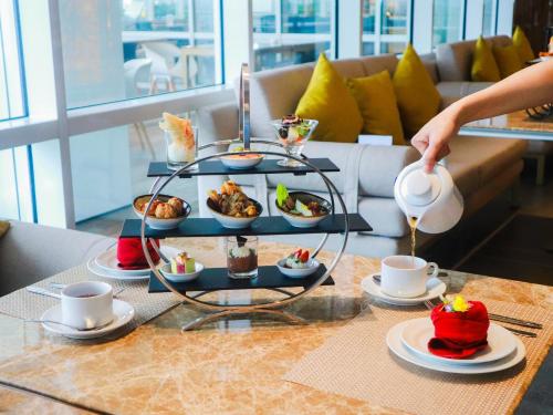 a tray of food on a table with cups of coffee at Nuanza Hotel & Convention Cikarang in Cikarang