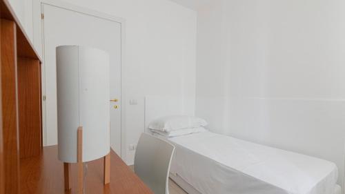a white bedroom with a bed and a white cabinet at Residenza Excelsior in Vasto