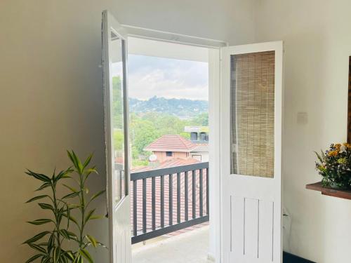 una puerta abierta con vistas a un balcón en LOUIS LAKE VILLA en Kandy