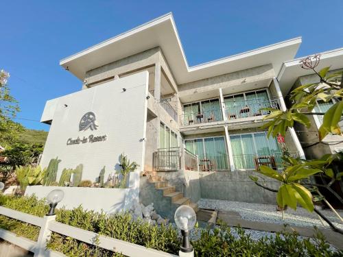 a large white house with a staircase in front of it at Check-in Resort Koh Larn in Ko Larn