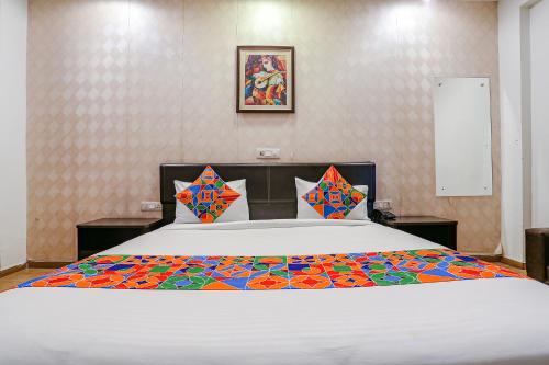 a large white bed with a colorful blanket on it at FabHotel Premium Nest in Gurgaon