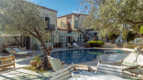 una piscina con sillas y mesas y una casa en Panjur Alaçatı, en Alacati