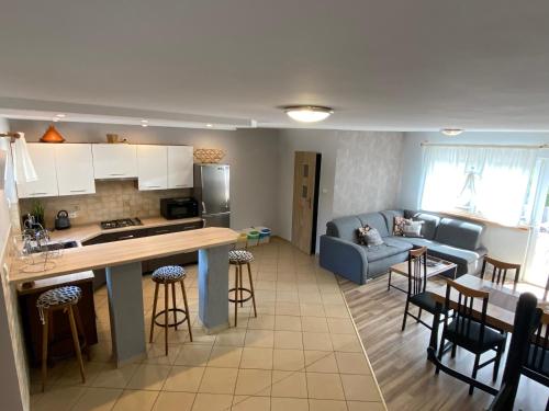 a kitchen and living room with a couch and a table at Domek Karinka in Mysłakowice