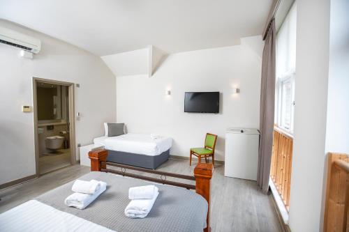 una camera con due letti e una tv di Arch Hotel a Londra