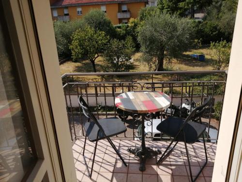 a patio table and chairs on a balcony at Ostello delle cartiere in Toscolano Maderno