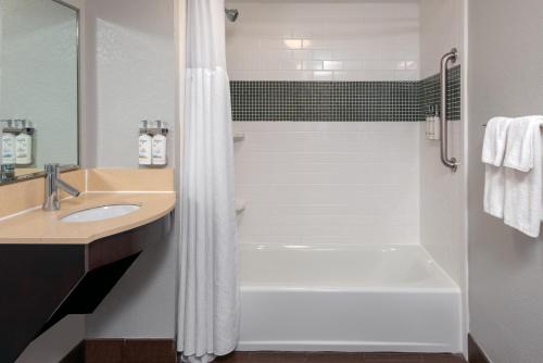 uma casa de banho com um chuveiro, um lavatório e uma banheira em Staybridge Suites Miami Doral Area, an IHG Hotel em Miami