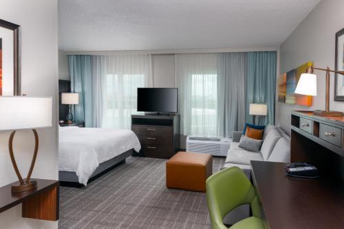 une chambre d'hôtel avec un lit et un canapé dans l'établissement Staybridge Suites Miami Doral Area, an IHG Hotel, à Miami