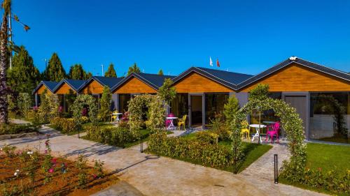 a row of houses with tables and chairs in a yard at Sandal Otel in Trabzon