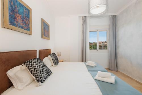 - une chambre avec un grand lit blanc et une fenêtre dans l'établissement Holiday home with private garden in Elviria , La Mairena, à Ojén