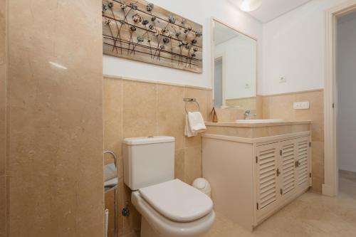 La salle de bains est pourvue de toilettes, d'un lavabo et d'un miroir. dans l'établissement Holiday home with private garden in Elviria , La Mairena, à Ojén
