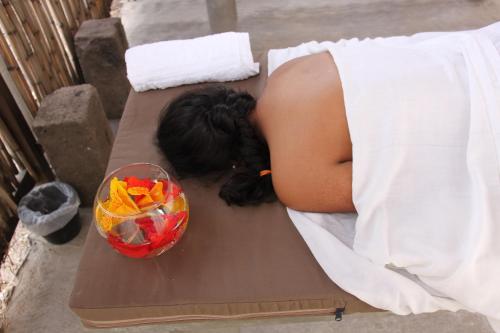 a woman laying in bed with her head on a table at Hotel SPA Villa San Agustin in Tecozautla
