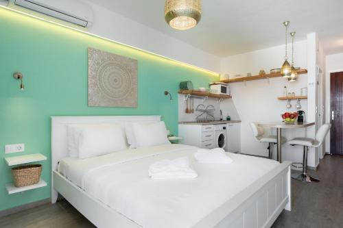 Schlafzimmer mit einem weißen Bett und einem Schreibtisch in der Unterkunft Seaside Secret by BluPine in Athen