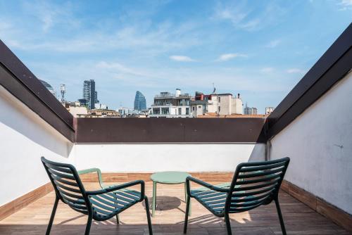 - un balcon avec vue doté de 2 chaises et d'une table dans l'établissement easyhomes - Brera Luxury Suites, à Milan