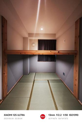 an empty room with a shelf on the ceiling at Sakae Guesthouse in Nagoya