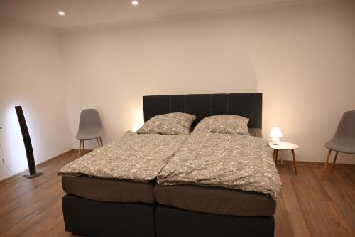 1 cama grande en una habitación con 2 sillas en Paula's Auszeit, en Weiersbach