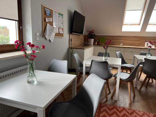 Noclegi Budomas Klima-ParkigFree-SmartTv في فروتسواف: غرفة طعام بها طاولات وكراسي وزهور