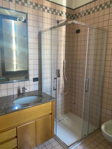 y baño con ducha acristalada y lavamanos. en Villa le Rondini, en Castronno