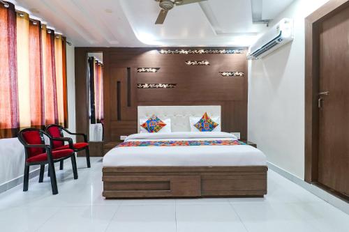 - une chambre avec un lit et une chaise rouge dans l'établissement FabHotel Nandgiri Palace Near Gwalior Junction Railway Station, à Gwalior