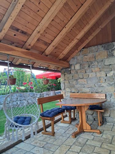 una mesa y sillas de madera bajo un techo de madera en Guest house Emanuela, en Slunj