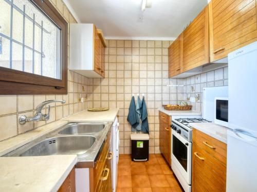 uma cozinha com um lavatório e um fogão em apartament amb piscina comunitària al Golfet em Calella de Palafrugell