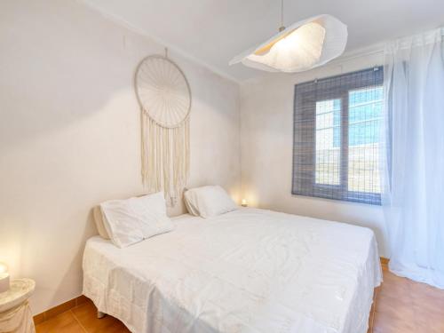 uma cama branca num quarto com uma janela em apartament amb piscina comunitària al Golfet em Calella de Palafrugell