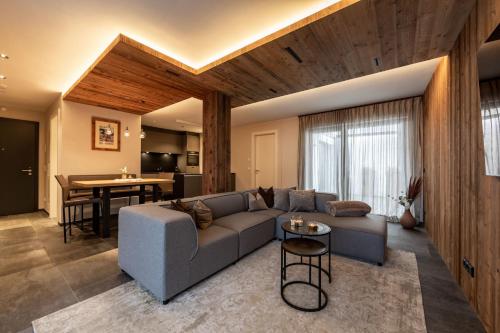 a living room with a couch and a table at Mountain Chalet Kirchberg by Apartment Managers in Kirchberg in Tirol