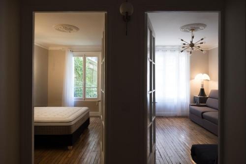 um quarto com uma cama, um sofá e uma janela em Montmartre sacré cœur em Paris