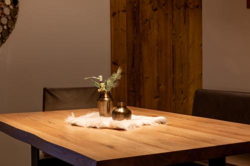 a wooden table with a vase on top of it at Mountain Chalet Kirchberg by Apartment Managers in Kirchberg in Tirol