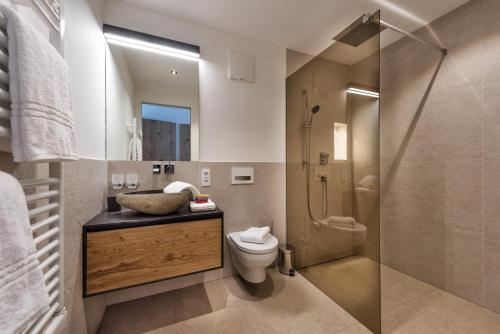 a bathroom with a shower and a toilet and a sink at Mountain Chalet Kirchberg by Apartment Managers in Kirchberg in Tirol