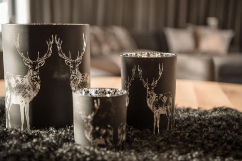 a table with two cups with deer figurines on it at Mountain Chalet Kirchberg by Apartment Managers in Kirchberg in Tirol