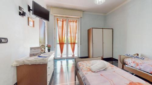 a bedroom with two beds and a desk and a window at House Antica Romana by Holiday World in Genoa