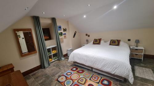 a bedroom with a white bed and a mirror at Cadshaw Country Views in Darwen