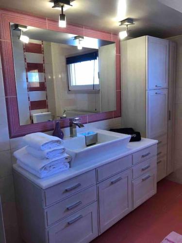 a bathroom with a sink and a large mirror at Villa Casa Chrissy in Plagiárion