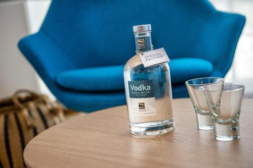 a bottle of vodka sitting on a table with two glasses at Mountain Chalet Kirchberg by Apartment Managers in Kirchberg in Tirol