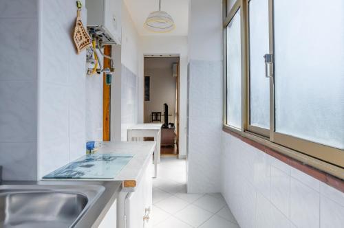 uma cozinha com um lavatório e uma janela em Viareggio Cozy Apartment with Balcony! em Viareggio