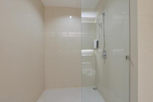 a white bathroom with a shower with a glass door at VST Residence -SHA PLUS Certified in Ban Khlong Bang Ping