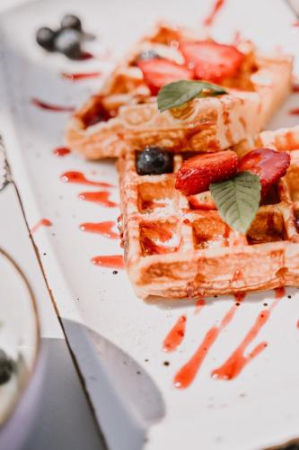 a plate of waffles with strawberries and fruit on it at Hotel Stomorin-Marina Hramina in Murter